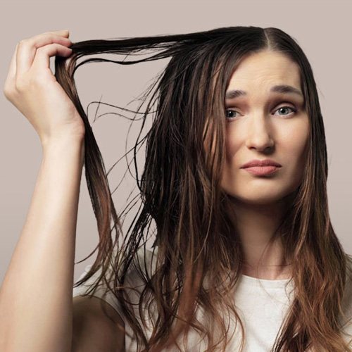 Ragazza triste con capelli sporchi bruni privi di volume